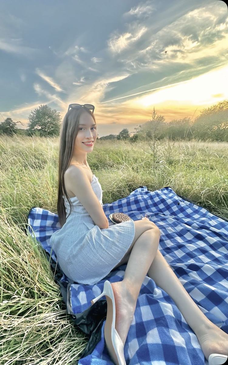 Portrait of Ema Muñoz, MD, smiling in a meadow at sunset